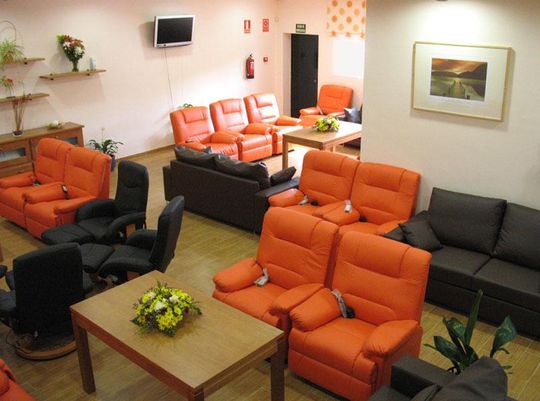 Salón con sillones negros y naranjas